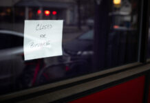 Trulieve Shutters California, Massachusetts Operations Hand written "Closed for Business" sign in the dark window of a shut down business