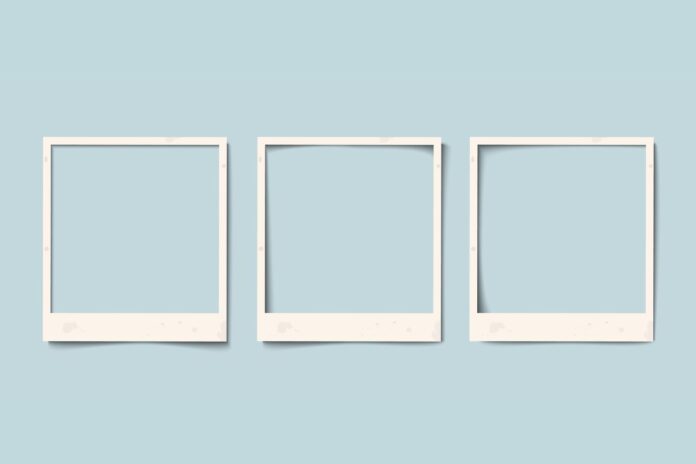 three white image frames on a blue wall