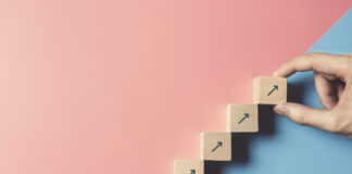 4 Things You Can Do to Move Your Business Forward Right Now Business concept growth success process, Close up man hand arranging wood block stacking as step stair on paper blue and pink background, copy space.