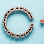 Analysis: Eliminating 280E Could Save 12 MSOs $700 Million Annually Disruption and technology transformation concept , Red arrow on wooden block cube move out from circle black arrow on blue background.