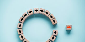 Analysis: Eliminating 280E Could Save 12 MSOs $700 Million Annually Disruption and technology transformation concept , Red arrow on wooden block cube move out from circle black arrow on blue background.