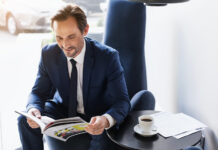 Defying Digital: The Resilience of Print Advertising in the Modern Age Businessman in suit reading magazine with morning coffee