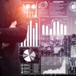 Cash Burn or Trust Earn: The Cannabis Investor’s Dilemma businessman in suit standing in front of a data analysis dashboards.