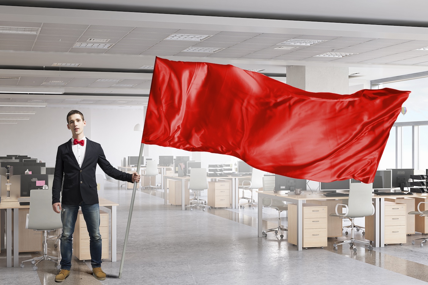 Man waving red flag warning at empty tech company