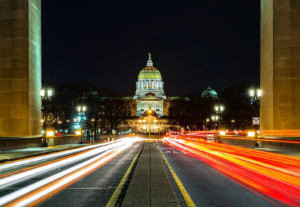 Pennsylvania state capitol at night with car lights streaking through with open camera shutter