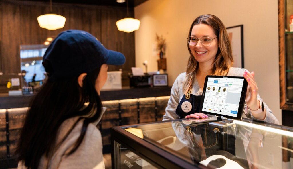 Female dispensary customer and female budtender conducting a sale using cova software