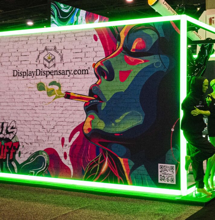 Graffiti-style mural at Display Dispensary's booth, featuring a neon green frame and the slogan &quot;Stuff That Sells Your Stuff.&quot;