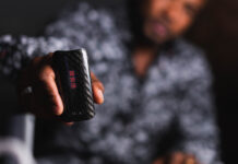 2025’s Must-Have Vapes: Top Brands & Game-Changing Tech Close-up of a person holding a DaVinci vaporizer with a carbon fiber finish, showcasing its sleek design and LED display.