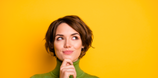 How 401(k) Plans Can Boost Employee Retention in the Cannabis Industry A thoughtful professional woman in a green turtleneck against a vibrant yellow background, symbolizing strategic financial planning and future growth.