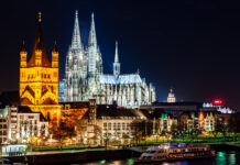 How International Cultivators Can Tap into Germany’s Cannabis Market Cologne Cathedral and Great St. Martin Church illuminated at night, symbolizing Germany’s growth.