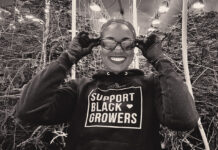 Why Women Are the Power Players in Cannabis — As Consumers and Entrepreneurs Rebecca Colett, CEO of Calyxeum, smiling in a cannabis cultivation facility while wearing a "Support Black Growers" hoodie.