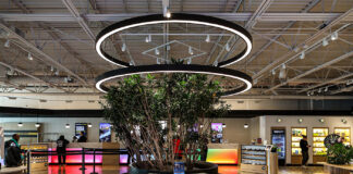 Revolution Cannabis: Blending Tech Innovation with Design Revolution dispensary interior in Illinois featuring modern circular lighting, lush greenery, and a sleek, open-concept layout designed for an intuitive shopping experience.