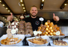 Spannabis 2025: How to Get the Most from the Show and Barcelona A smiling vendor at a Barcelona food stall offering an assortment of churros, donuts, and pastries at Spannabis 2024.