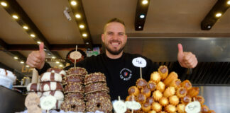Spannabis 2025: How to Get the Most from the Show and Barcelona A smiling vendor at a Barcelona food stall offering an assortment of churros, donuts, and pastries at Spannabis 2024.