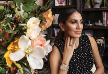 Marie Saloum Marie Saloum seated beside a vibrant floral arrangement, wearing elegant jewelry and a black polka-dot dress, inside her office space featured in Executive Insight by Macey Wolfer.