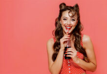 Cannabis-Infused Beverages Bubble Up in Popularity Woman posing in retro attire with a cannabis beverage in her hands
