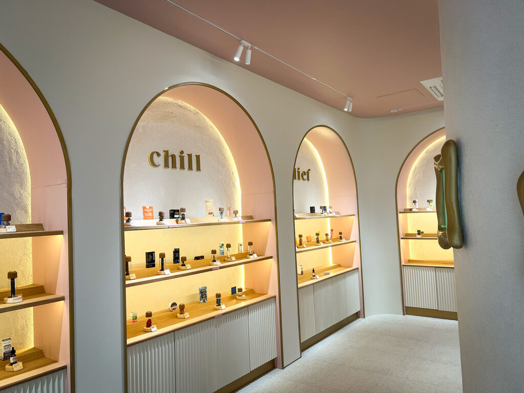 Illuminated product displays at Alta organized under arched wall niches labeled “chill” and “relief.”