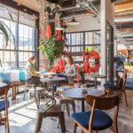 Employer Branding: Building Culture as Your Competitive Edge Modern cannabis company workspace with open layout, natural light, and casual employee conversation reflecting culture and connection.