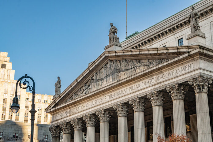 New York State Supreme Court building in Manhattan with inscription emphasizing justice, related to injunction blocking OCM dispensary closures.