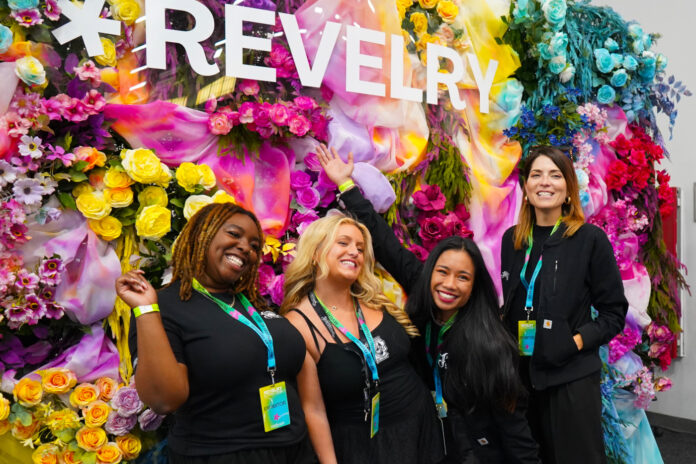 Group of women posing in front of a colorful flower wall at Revelry 2025 cannabis trade show in New York City