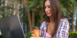 4 Restriction-Proof Ways to Get Cannabis Content Seen Digital marketer working on a laptop, illustrating resilient outreach and content distribution strategies for cannabis brands operating under advertising restrictions.