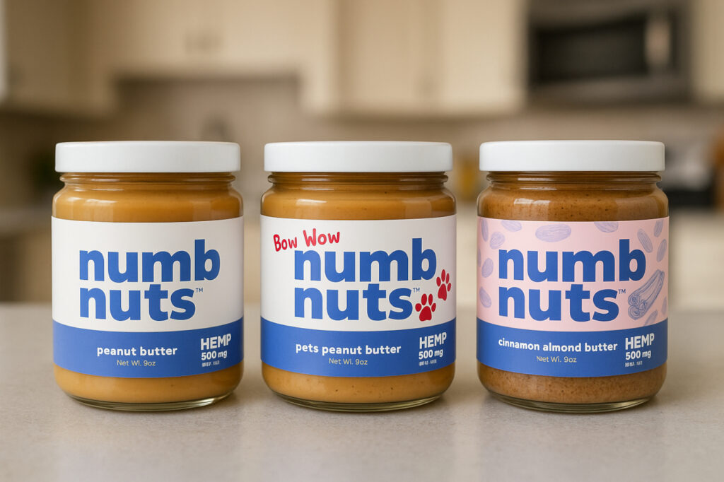 Three jars of Numb Nuts hemp-infused nut butters lined up on a kitchen counter, including peanut butter, pets peanut butter, and cinnamon almond butter.