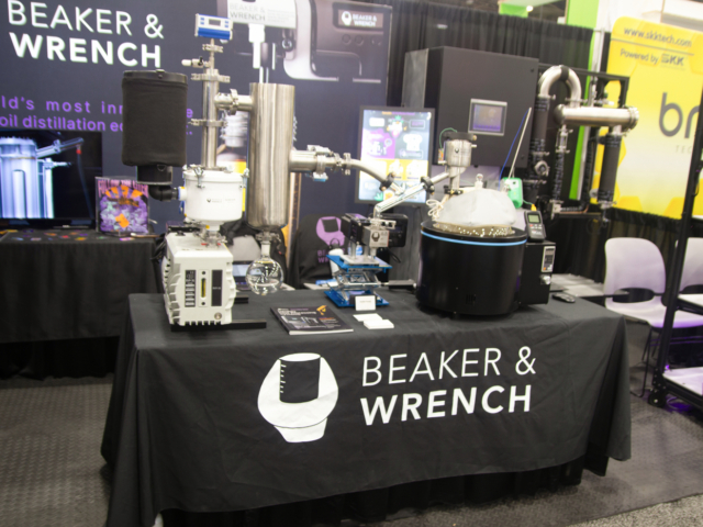 Beaker &amp; Wrench booth displaying cannabis oil distillation equipment at MJBizCon 2025.