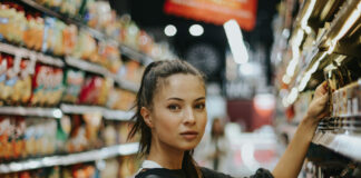 2026 Cannabis Marketing Playbook: Consumer Shifts You Can’t Ignore A shopper evaluates products in a retail aisle, illustrating the data-driven, wellness-focused decision-making shaping cannabis consumer behavior in 2026.