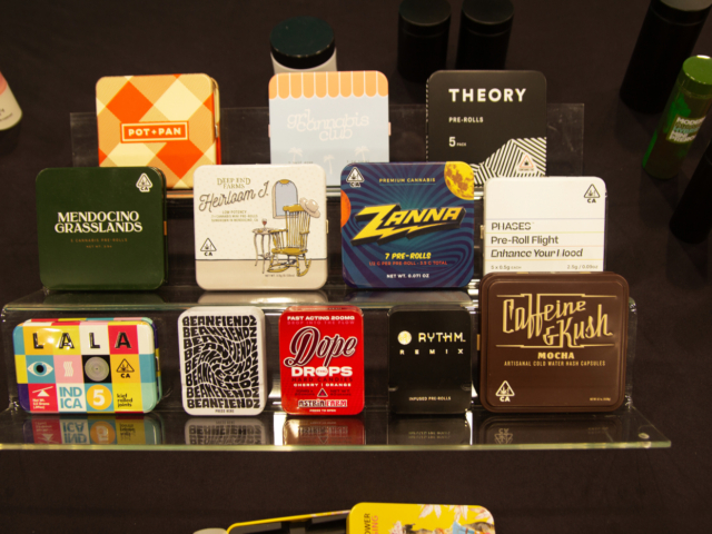Collection of branded cannabis pre-roll tins from various companies displayed at MJBizCon 2025.