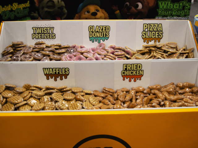 Munchies cannabis-themed dog treats shaped like pretzels, donuts, waffles, pizza slices, and chicken at MJBizCon 2025.
