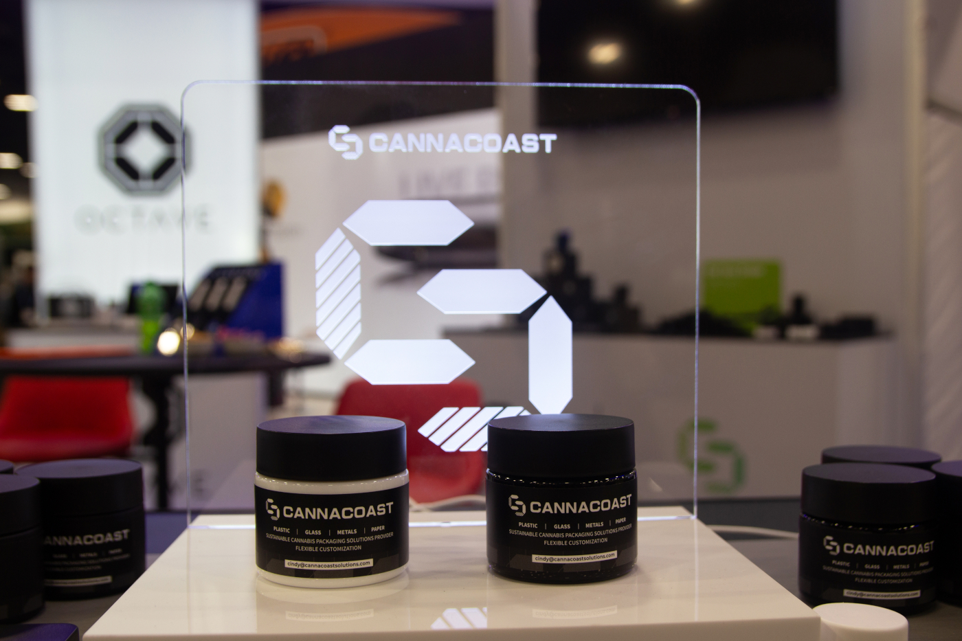 CannaCoast display of sustainable cannabis jars with illuminated logo at MJBizCon 2025.