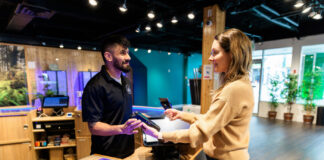 Strong Dispensary Partnerships Build Lasting Cannabis Brands A budtender assists a customer with a purchase at a cannabis dispensary.