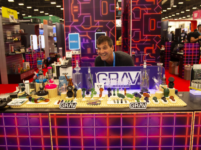 GRAV booth at MJBizCon 2025 featuring an array of cannabis glass pipes, bongs, and rigs.