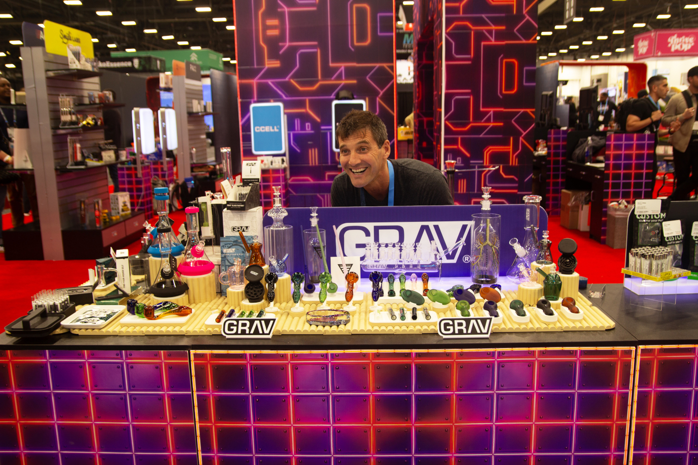 GRAV booth at MJBizCon 2025 featuring an array of cannabis glass pipes, bongs, and rigs.