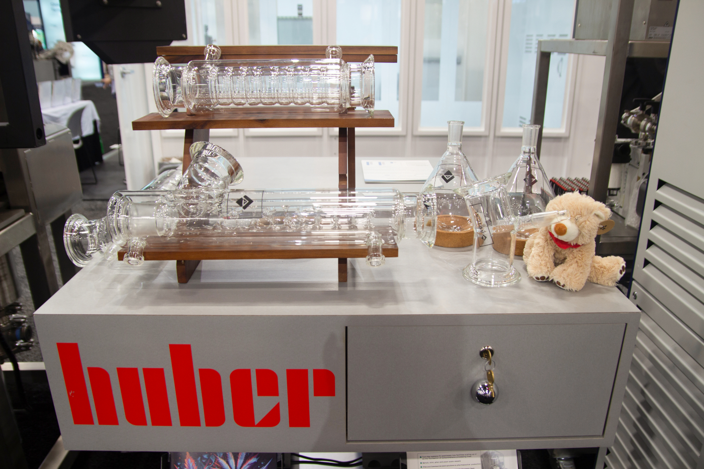 Huber booth at MJBizCon 2025 featuring scientific glassware and lab equipment for cannabis extraction.