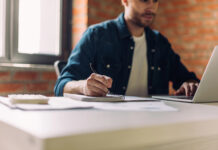 Pisgah Peaks Ventures on Building Marketing Teams That Scale Marketing consultant taking notes while reviewing strategy on a laptop in a light, modern workspace.