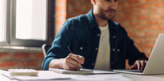 Pisgah Peaks Ventures on Building Marketing Teams That Scale Marketing consultant taking notes while reviewing strategy on a laptop in a light, modern workspace.