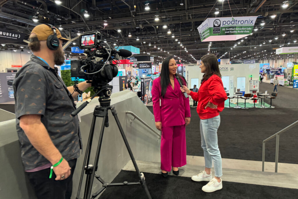 A spokesperson participates in an on-camera interview at a cannabis trade show, demonstrating media readiness and earned visibility.