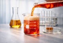 The Hidden Science Behind Successful Cannabis Beverages Colorful fizzy beverage being poured into a laboratory beaker, illustrating the science behind cannabis drink flavor.