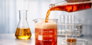 The Hidden Science Behind Successful Cannabis Beverages Colorful fizzy beverage being poured into a laboratory beaker, illustrating the science behind cannabis drink flavor.