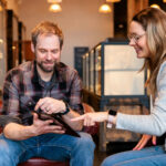 Beyond the Transaction: Empathy and Simplicity in Cannabis Retail A budtender and customer sitting on a couch in a modern dispensary, demonstrating a simplified and empathetic cannabis retail experience.