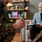 Clenched fists of a military veteran in uniform, representing the stress and frustration of the impending 2026 medical hemp access crisis.