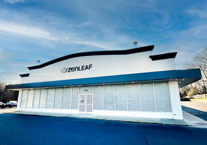 Zen Leaf dispensary exterior in Neptune, New Jersey, showing a wide building facade and parking area in front.