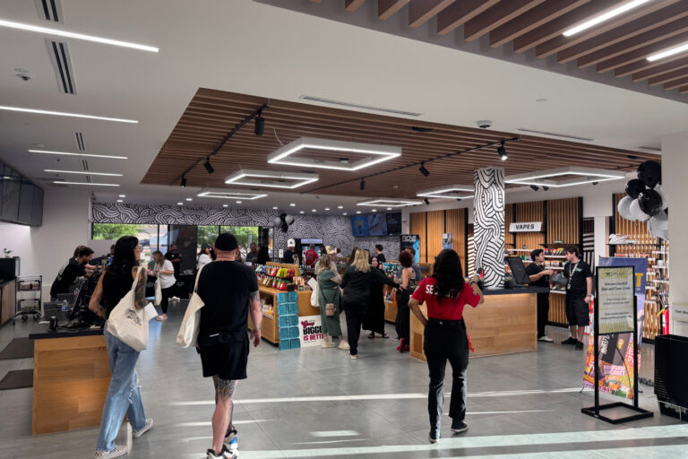 Customers browse product displays inside a Zen Leaf dispensary with warm wood fixtures and modern overhead lighting.