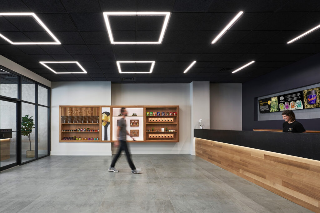 Open Zen Leaf dispensary sales floor with wood display fixtures, product showcases, and staff assisting customers in the background.