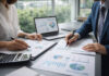 How Cannabis Businesses Should Prepare for a Potential End to 280E Two business professionals review financial charts and compliance documents at a desk with a laptop in a modern office.