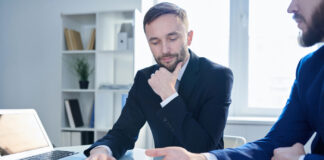 How to Build Cannabis Banking’s Missing Trust Layer A cannabis business operator and a banker discussing financial reports to build trust.