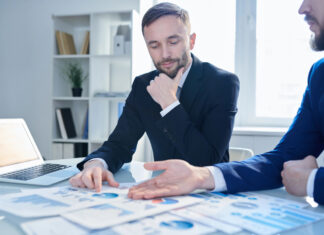 How to Build Cannabis Banking’s Missing Trust Layer A cannabis business operator and a banker discussing financial reports to build trust.