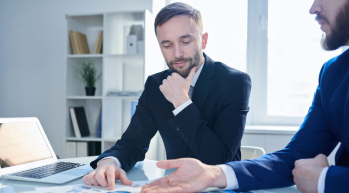 How to Build Cannabis Banking’s Missing Trust Layer A cannabis business operator and a banker discussing financial reports to build trust.