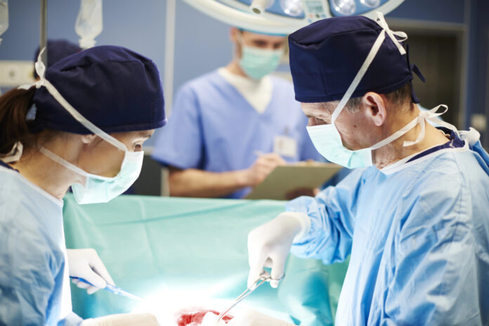 Surgeons in a clinical setting preparing for a procedure; used to illustrate medical cannabis transplant eligibility.